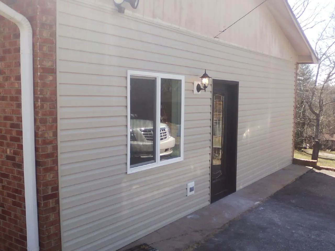 New vinyl siding and entry door on a room addition in Colbert