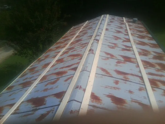 Rusted metal roof panels with new wood purlins before replacement — Storm Damage Roof Repair in Colbert by Roofing Brothers