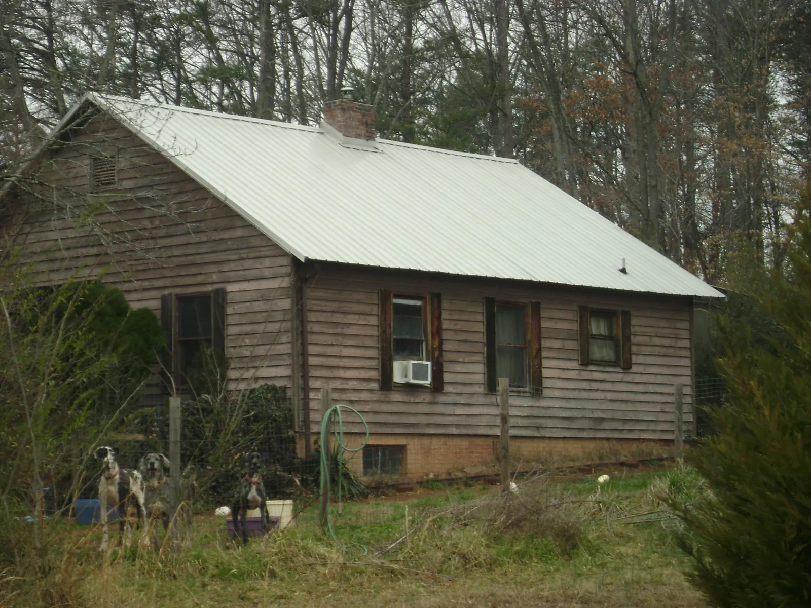 White metal roof on an old wood sided farmhouse, from a Metal Roof Installation job in Colbert